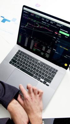 person using macbook pro on white table