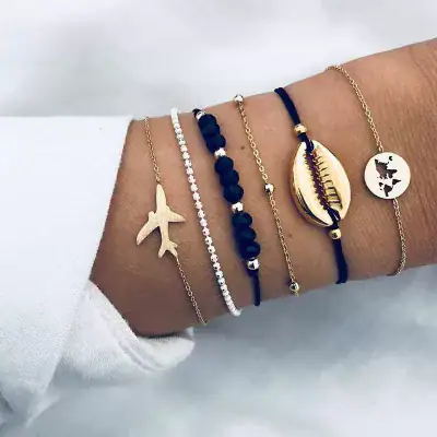 Delicate layered bracelets featuring travel, ocean, and world motifs, perfect for stylish accessories and travel-themed jewelry lovers.