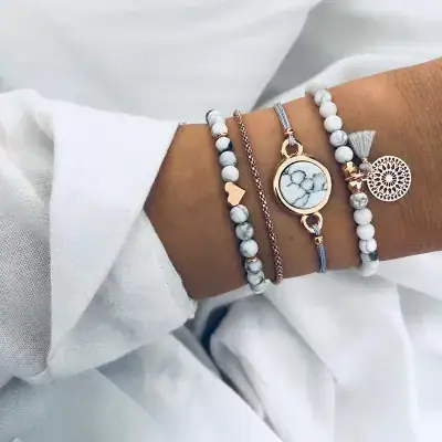 Delicate marble-themed bracelets and necklace on a woman's wrist, perfect for stylish accessories and jewelry lovers. High-quality design and trendy fashion jewelry for women.