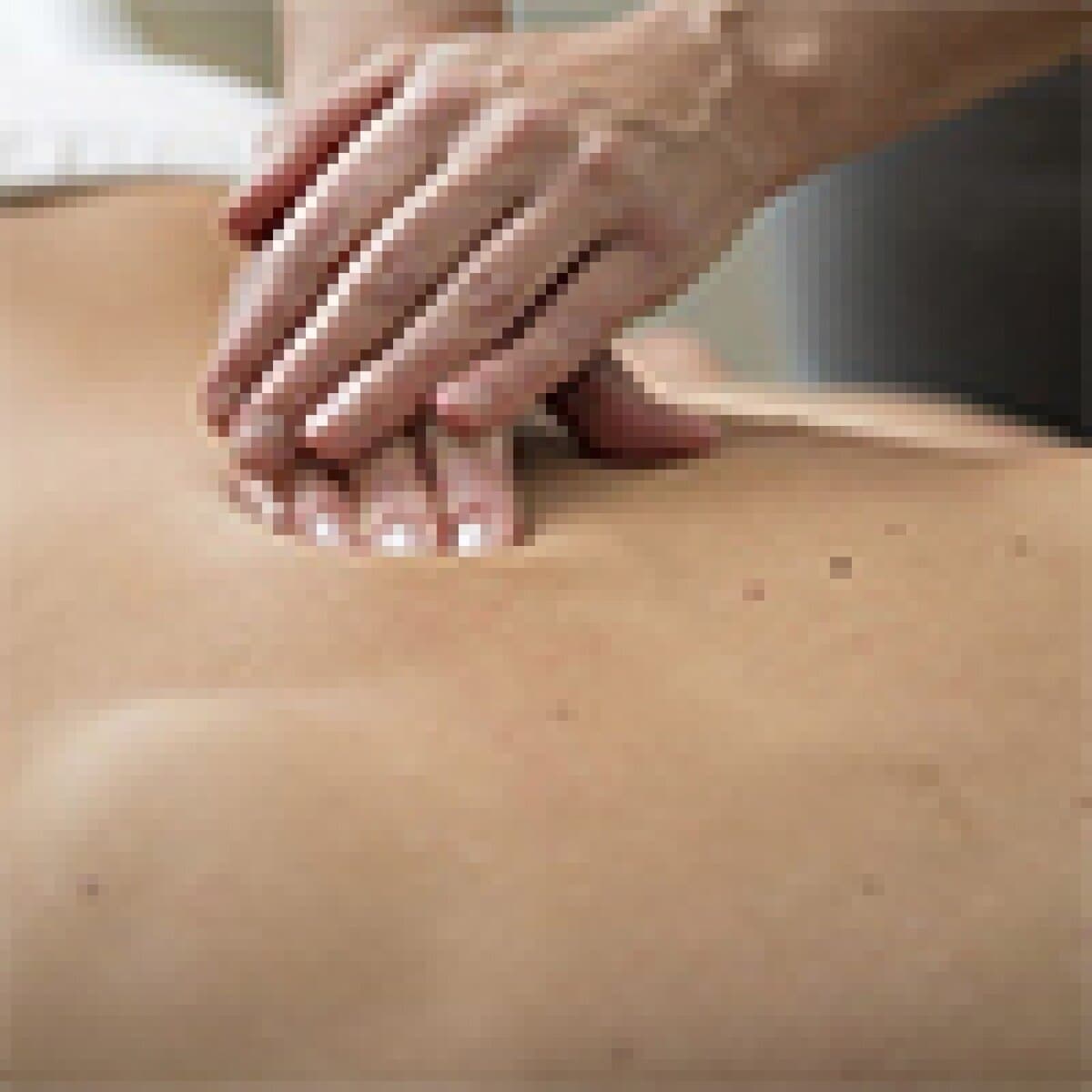 Close-up of a professional relaxing a client's back during a massage session at Monalisa Medical Spa.