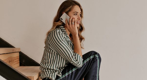 Young woman talking on phone, smiling, casual wear, modern lifestyle, indoor scene at Monalisa Medical store.