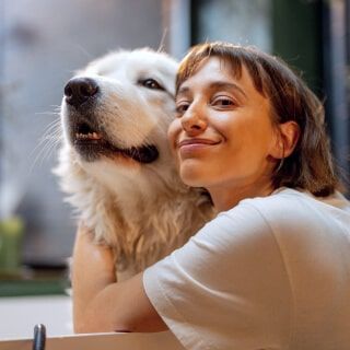 Happy woman with large dog, embracing outdoors, showcasing love and companionship, promoting pet wellness products at Monalisa Medical.