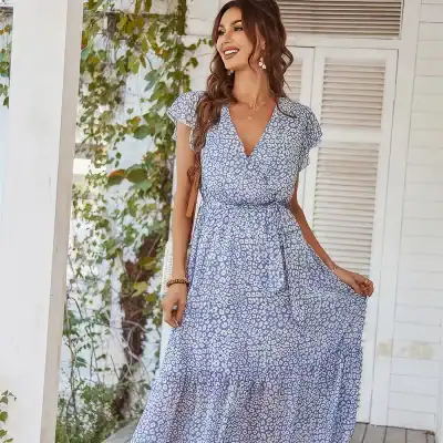 Woman wearing stylish blue animal print maxi dress with short sleeves and V-neckline, perfect for casual summer outings and beach vacations.