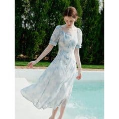 Delicate light blue and white floral dress with puffed sleeves, airy and stylish for outdoor summer occasions.