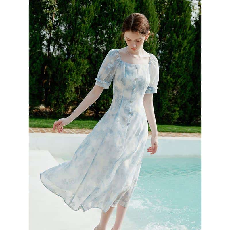 Delicate light blue and white floral dress with puffed sleeves, airy and stylish for outdoor summer occasions.