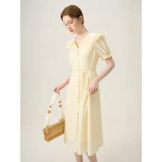 Beautiful pastel yellow dress with puff sleeves, button-down front, and waist tie, perfect for casual or dressy occasions. Crafted with lightweight fabric for comfort and style.