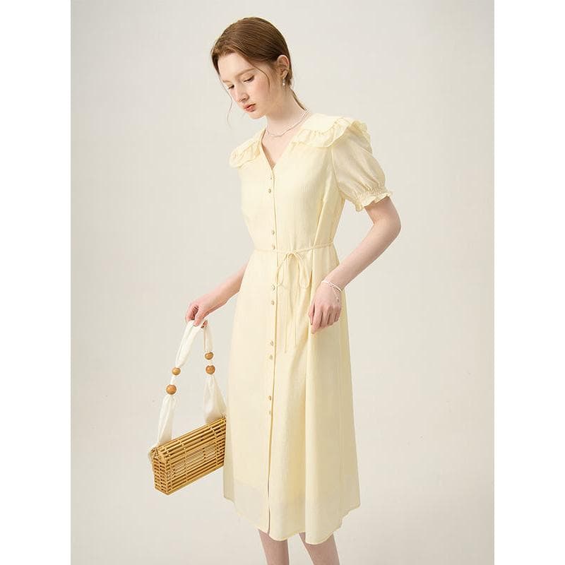 Beautiful pastel yellow dress with puff sleeves, button-down front, and waist tie, perfect for casual or dressy occasions. Crafted with lightweight fabric for comfort and style.