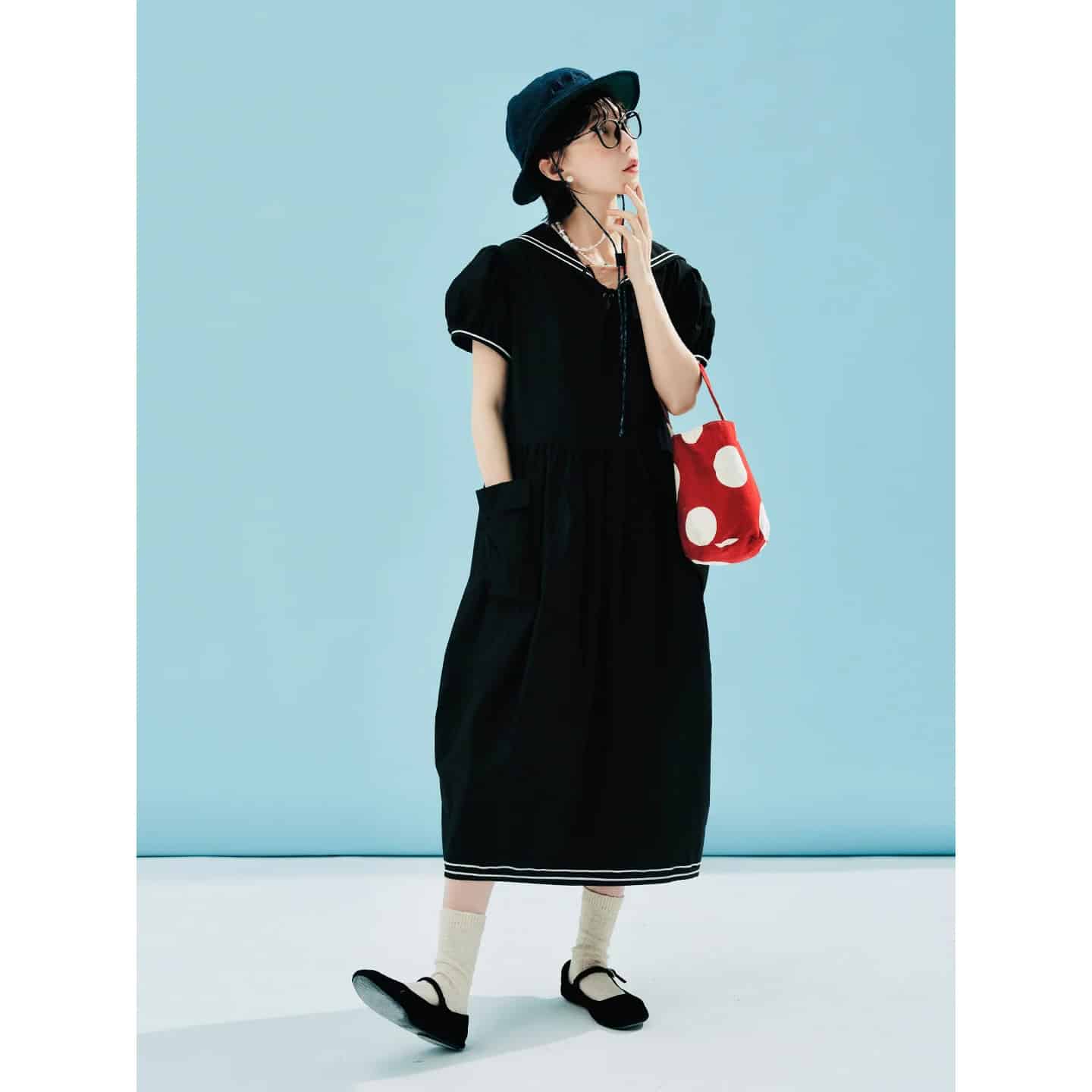 Elegant women's black dress with sailor collar, puffy sleeves, and white stripe details, paired with black Mary Jane shoes, beige socks, and a stylish black hat, perfect for casual or semi-formal occasions.