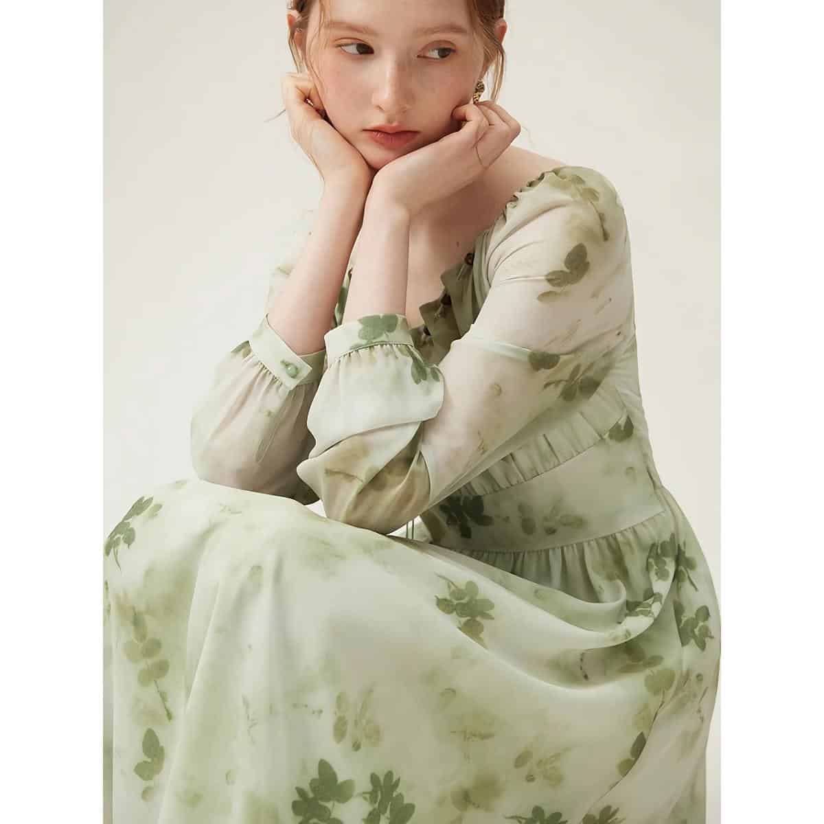 Young woman wearing a delicate, floral-printed dress in muted green tones, perfect for casual or special occasions.