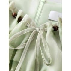 Close-up of a soft silk eyeglasses case with a delicate bow and wooden bead closure, perfect for maintaining your sunglasses or optical frames. Discover stylish eyewear accessories at Monalisa Store.