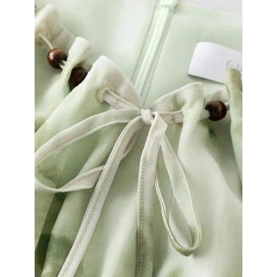 Close-up of a soft silk eyeglasses case with a delicate bow and wooden bead closure, perfect for maintaining your sunglasses or optical frames. Discover stylish eyewear accessories at Monalisa Store.