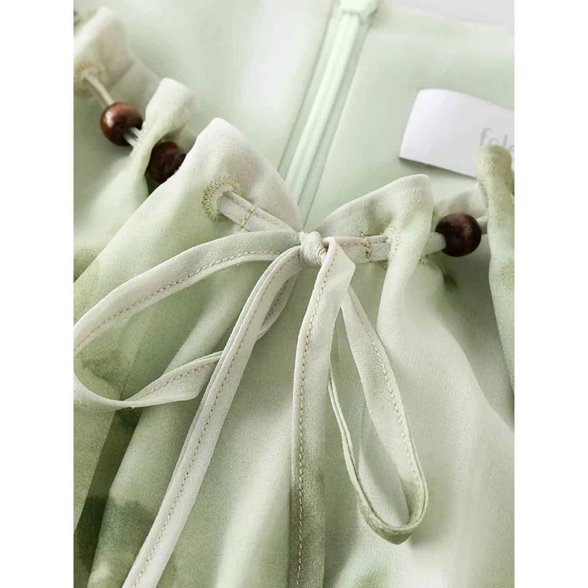 Close-up of a soft silk eyeglasses case with a delicate bow and wooden bead closure, perfect for maintaining your sunglasses or optical frames. Discover stylish eyewear accessories at Monalisa Store.