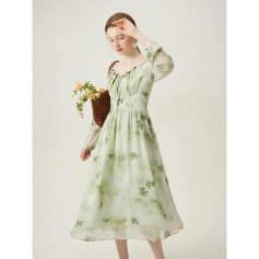 Beautiful woman in a flowy light green floral dress with sheer long sleeves, holding a woven basket with flowers, showcasing stylish and comfortable women's fashion from Monalisa Medical Store.