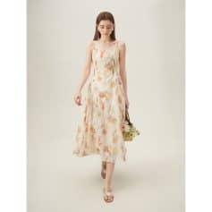 A woman modeling a stylish, floral summer dress with thin straps, perfect for warm weather and fashionable outings.