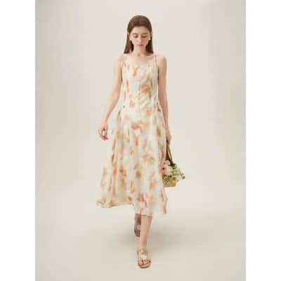 A woman modeling a stylish, floral summer dress with thin straps, perfect for warm weather and fashionable outings.