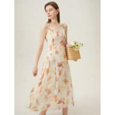 Beautiful woman wearing a flowy, floral-printed summer dress with thin straps, perfect for warm weather and casual occasions.