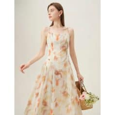 A young woman models a flowy, pastel-colored floral dress with spaghetti straps, highlighting versatile summer fashion options available at Monalisa Store.