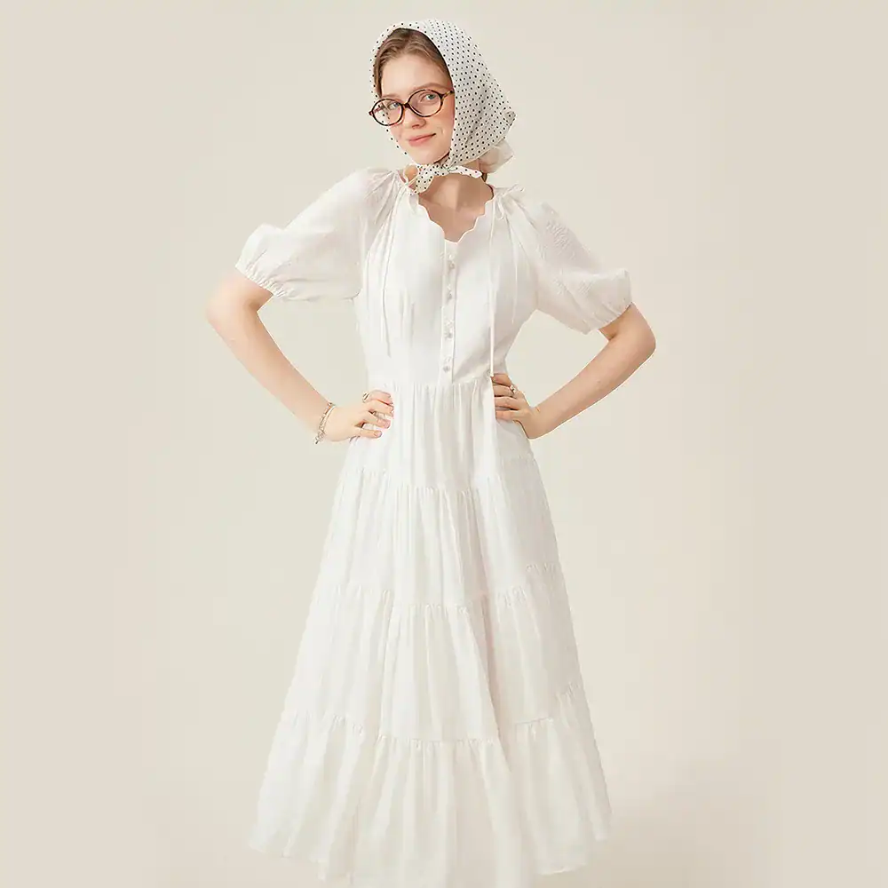Fashionable white maxi dress with puff sleeves, button-front, and tiered skirt, perfect for summer and chic occasions at Monalisa Medical store.