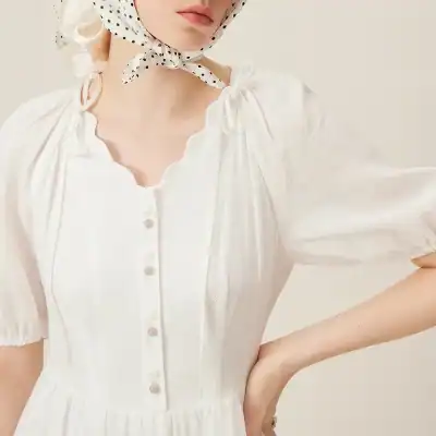 Image of a stylish white dress with puffed sleeves and button details, perfect for fashion-forward women. Discover more trendy women's clothing options at Monalisa Store for elegant and chic style.