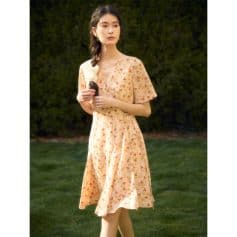 A stylish, light peach floral dress perfect for spring and summer, featuring a V-neck, short sleeves, and flattering A-line silhouette, ideal for casual outings or outdoor events.