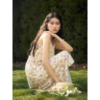 Stunning young woman in floral dress sitting outdoors, showcasing beauty and fashion accessories, perfect for opt and eyewear branding.