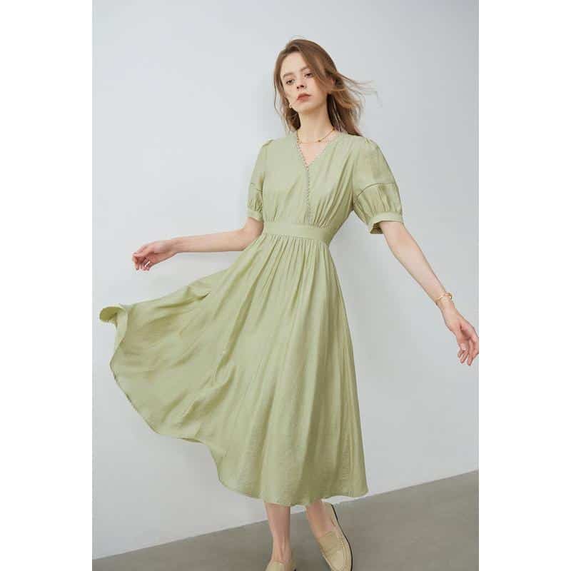 Image shows a woman in a light green, flowy dress, perfect for casual or semi-formal occasions, emphasizing comfort and style.