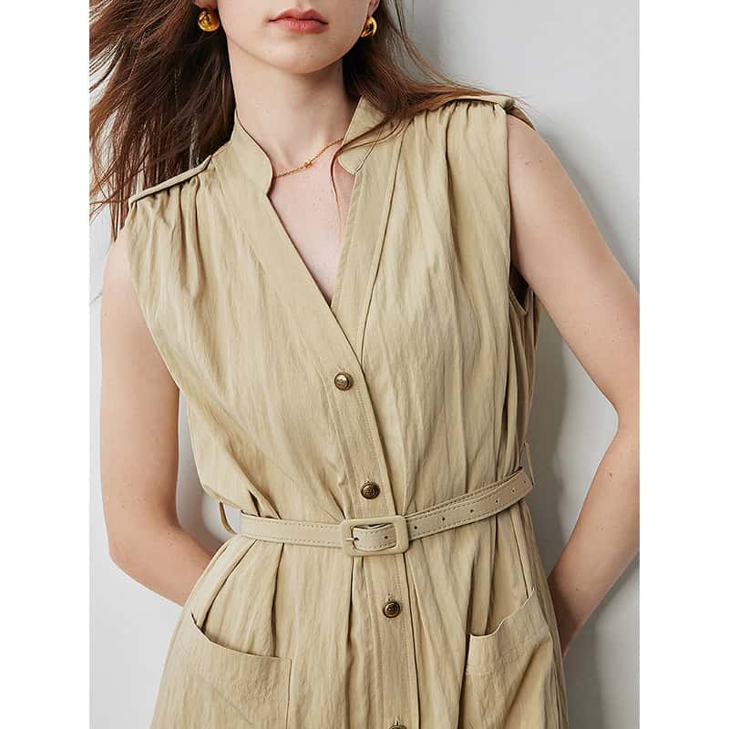 A stylish sleeveless beige dress with a belted waist, button-up front, and pleated pockets, perfect for fashionable women seeking versatile, chic clothing options at Monalisa Medical Store.