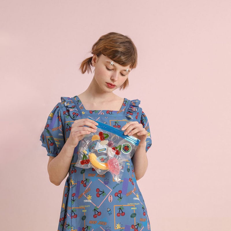 Young woman holding a bag of colorful sweets, playful and vibrant, showcasing trendy fashion and fun accessories for a youthful, cheerful look.