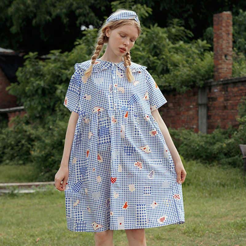 Stylish women's dress with a blue and white checkered pattern and playful fruit and flower prints, perfect for casual outings and garden parties.