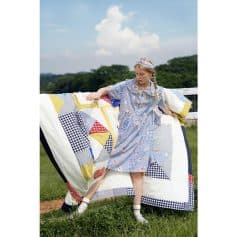 Bright and colorful girl wearing patchwork dress with optical frames in natural outdoor setting.