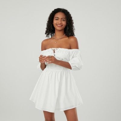 Elegant woman in white off-shoulder dress with accessories, perfect for summer, fashion, and casual wear.