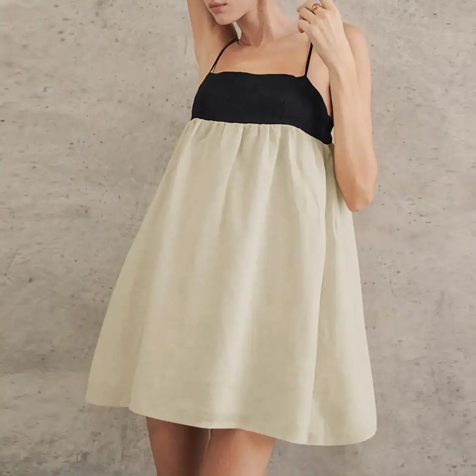 Elegant summer dress featuring a black sleeveless top with thin straps and a flowing cream-colored skirt, perfect for warm weather and stylish occasions.