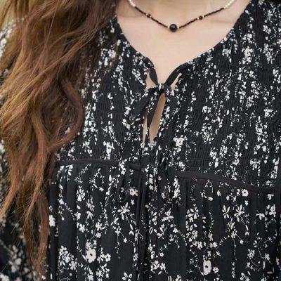 An elegant black and white floral dress with a tie-front neckline, perfect for stylish occasions.