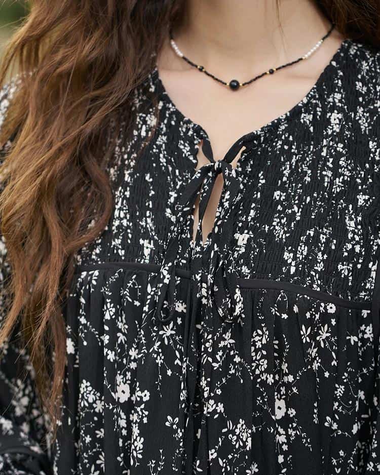 An elegant black and white floral dress with a tie-front neckline, perfect for stylish occasions.