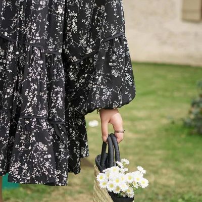 An elegant black and white floral dress with puffed sleeves, perfect for casual or semi-formal occasions. Showcasing timeless design and comfort for confident women.