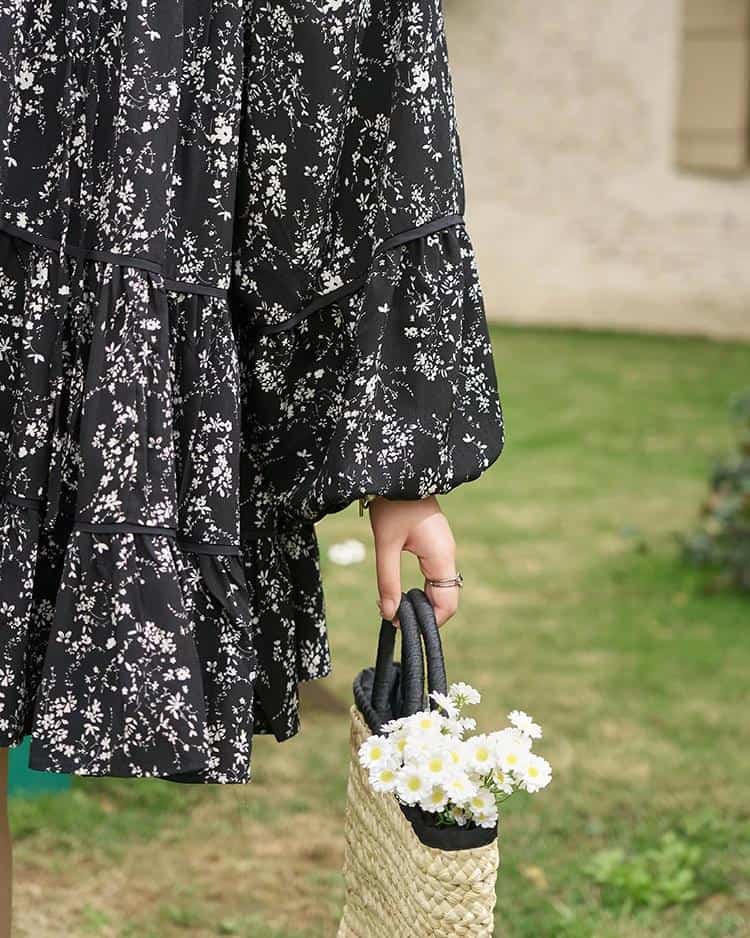 An elegant black and white floral dress with puffed sleeves, perfect for casual or semi-formal occasions. Showcasing timeless design and comfort for confident women.
