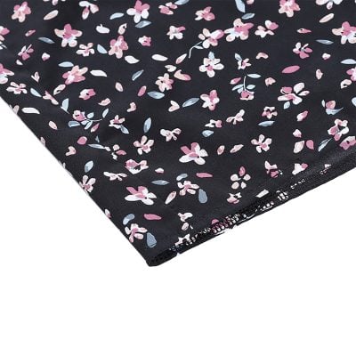 Bright, detailed fabric with pink, white, and blue flowers on a black background, ideal for making fashionable clothing items, accessories, or home decor.