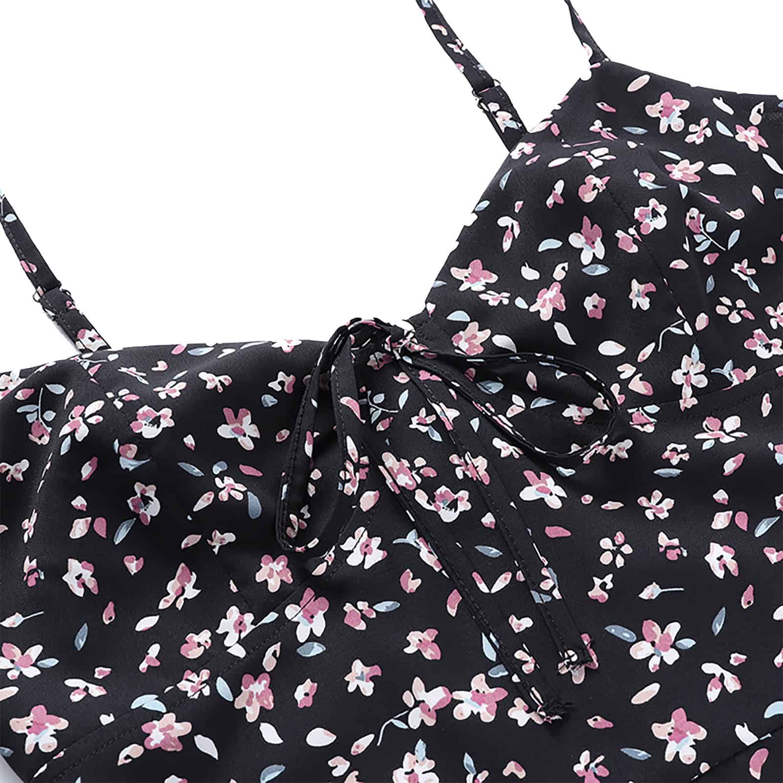 Brightly colored floral dress featuring a black background and pink, white, and blue flower print. Includes adjustable spaghetti straps and a tied bow at the waist for a flattering fit. Ideal for spring or summer fashion.
