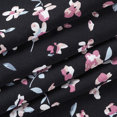 Close-up of black floral mesh fabric featuring pink and white flower patterns, ideal for fashion, clothing, and accessories. Perfect for elegant, trendy designs.