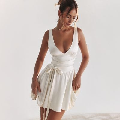 Stylish white sleeveless wedding dress with deep V neckline and waist tie, perfect for bridal occasions. Experience high-quality bridal fashion options at Monalisa Medical.