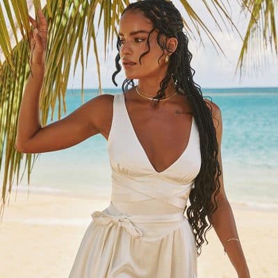 Stylish women's resort wear, perfect for beach vacations, featuring a chic white dress with a deep V-neck and waist tie. Ideal for summer, vacation, and resort fashion.