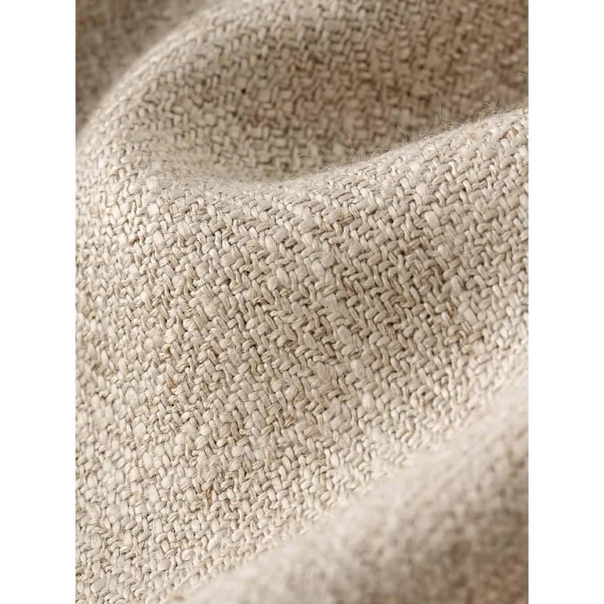 Close-up of woven beige fabric, highlighting textured material used for store decor or display accessories at Monalisa Store.