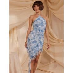 A fashionable woman wears a blue tie-dye halter dress with ruffled hem, perfect for summer events and stylish gatherings.