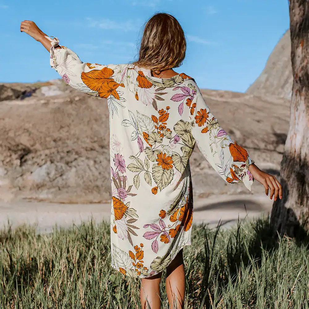A woman wearing a floral dress enjoying outdoors, showcasing vibrant summer fashion ideal for women’s casual and resort wear, perfect for outdoor activities and stylish summer occasions.