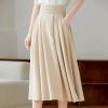 Elegant beige pleated midi skirt, perfect for professional or casual wear, featuring a high waist and flowing silhouette.
