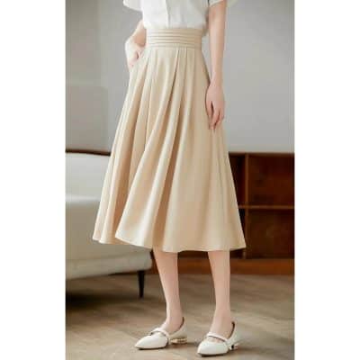 High-resolution image showcasing a stylish beige midi skirt with pleats, perfect for fashionable women seeking quality and comfort in their wardrobe.