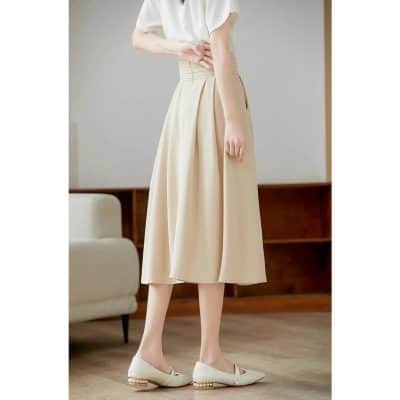 Beige midi skirt with pleats, high waist, and flowy design, perfect for women's fashion. Ideal for office wear, casual outings, or stylish events. Made with quality material for comfort and elegance.
