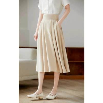 Stylish beige midi skirt with pleats, perfect for professional or casual occasions, featuring a high waist and flowy design.