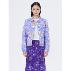 A woman wearing a colorful, bubble-patterned denim jacket and matching skirt designed for stylish optical eyewear fashion. Perfect for modern, trendy eyewear enthusiasts.