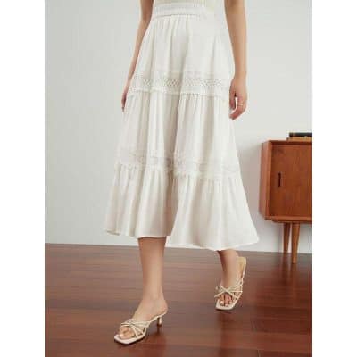 A stylish white maxi skirt featuring lace detailing and a flowy silhouette, perfect for summer outings and casual-chic fashion.